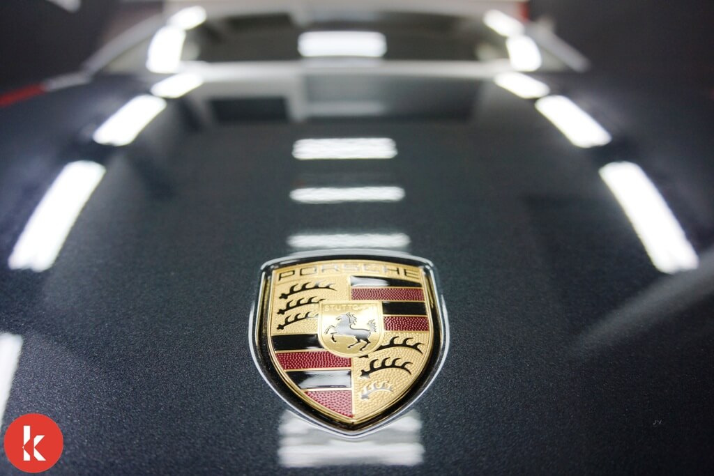 Porsche emblem on dark car hood