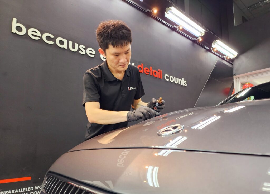 Technician applying ceramic coating to gray car
